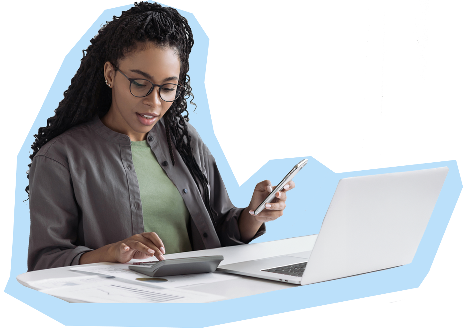 Confident professional working at desk using calculator with laptop phone and documents